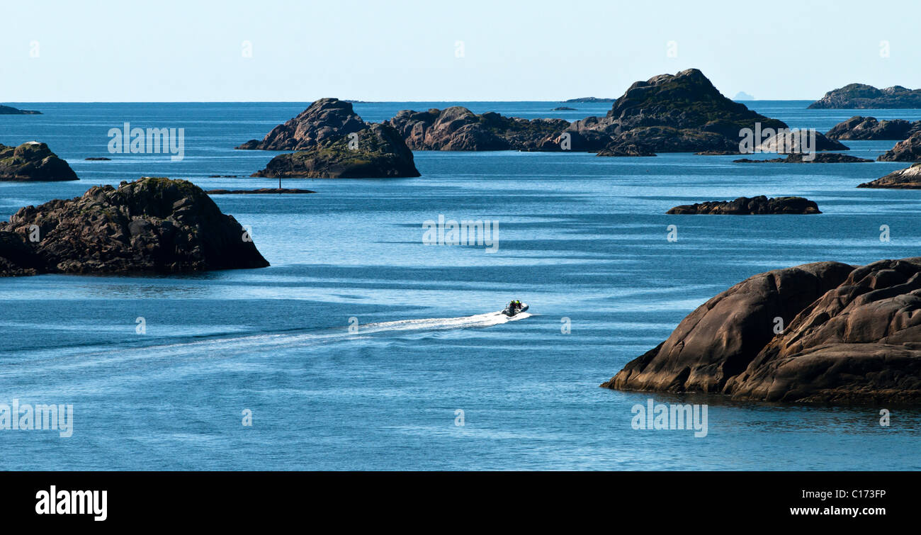 Lofoten-Inseln, weit oben im Norden in der norwegischen Arktis. Kleine Boot Wettrennen zwischen den riesigen Felsen entlang der Küste Stockfoto