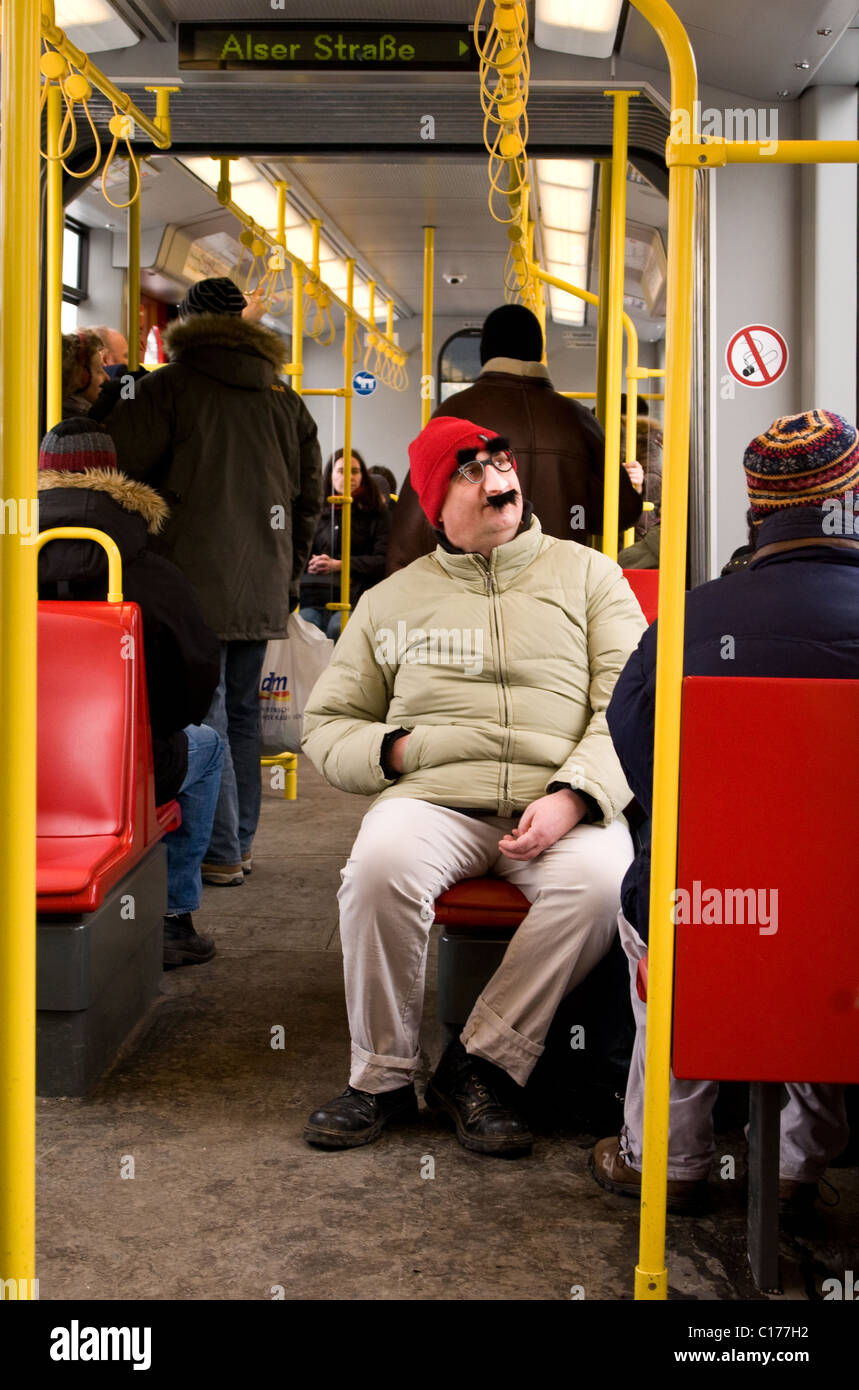 Passagier sitzt in der u-Bahn in einen roten Hut und Verkleidung Kit. Stockfoto