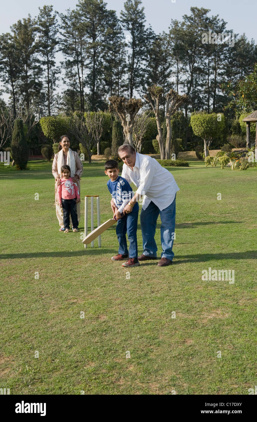 Familie spielen Cricket in Rasen Stockfoto