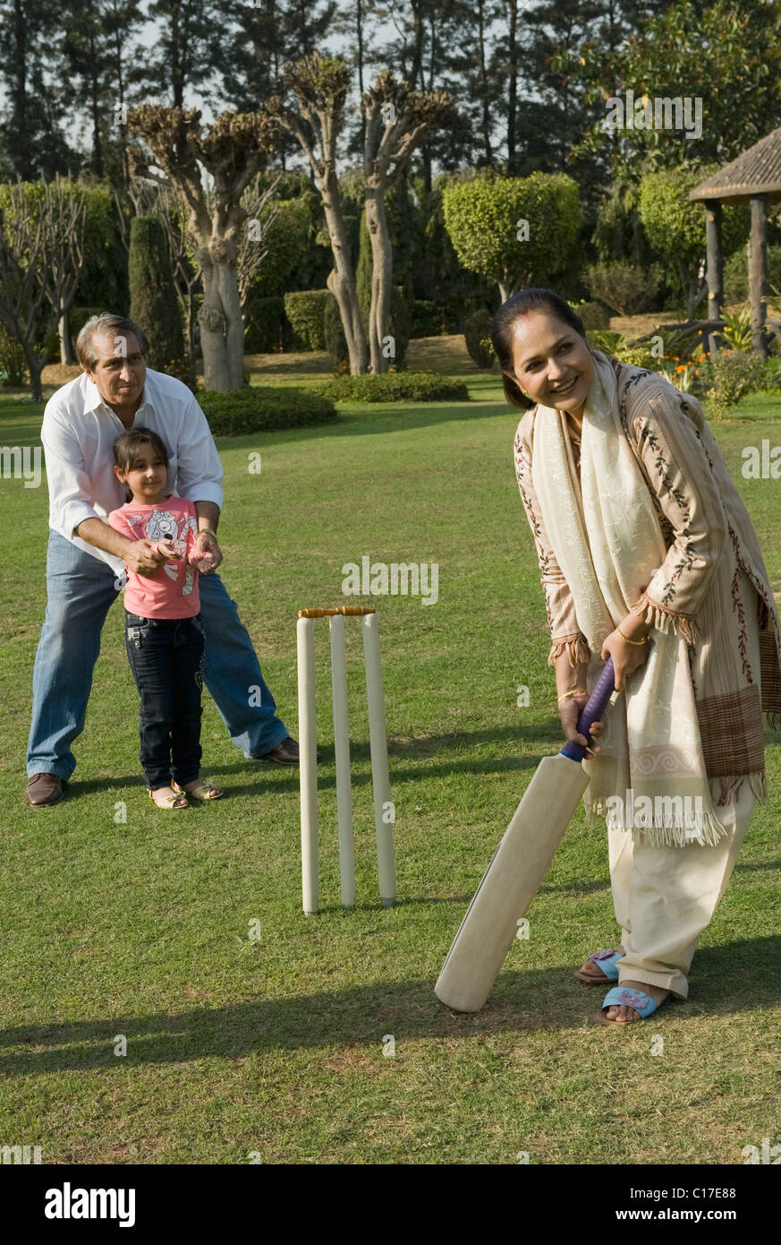 Familie spielen Cricket in Rasen Stockfoto