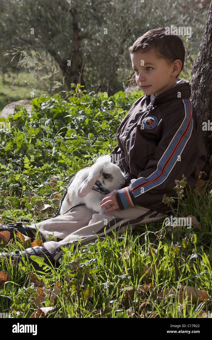 kleiner Junge mit Haustier Kaninchen an der Leine Stockfoto