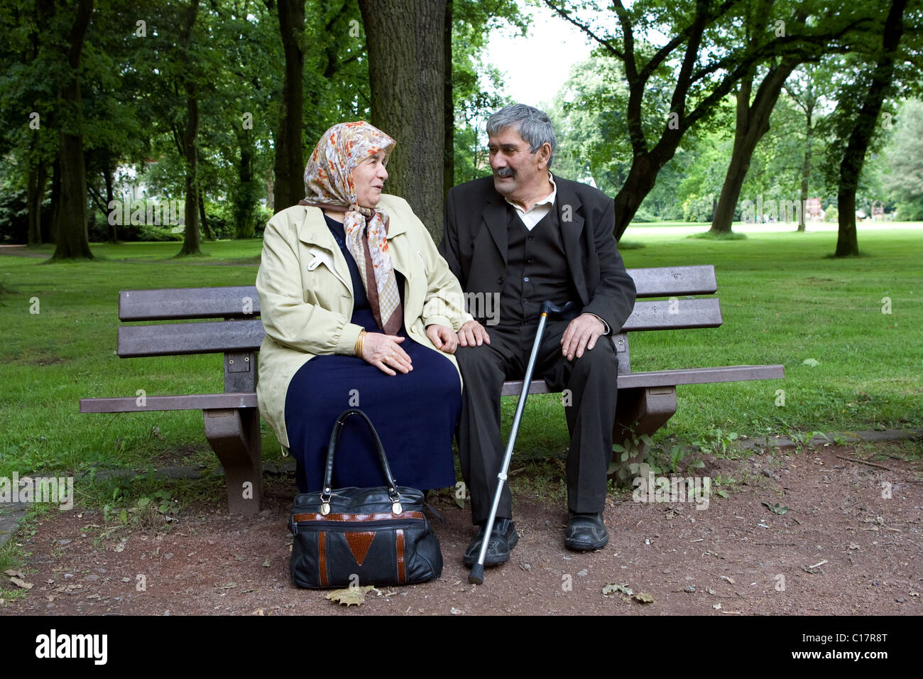 Ein älteres türkischen Ehepaar sitzt auf einer Bank in einem Park, Herne, Deutschland Stockfoto