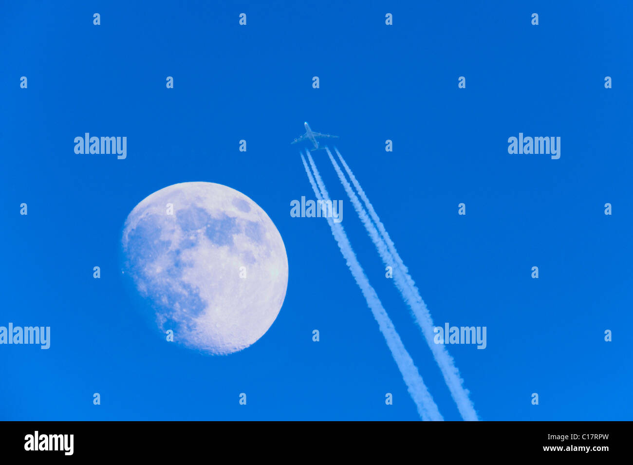 Passagierflugzeuge mit Jet Trail und Mond Stockfoto