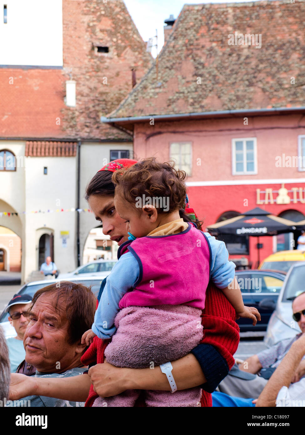 Gipsy Frau Bettler, halten ein kleines Kind beim betteln um ein offenes Restaurant in Rumänien. Stockfoto