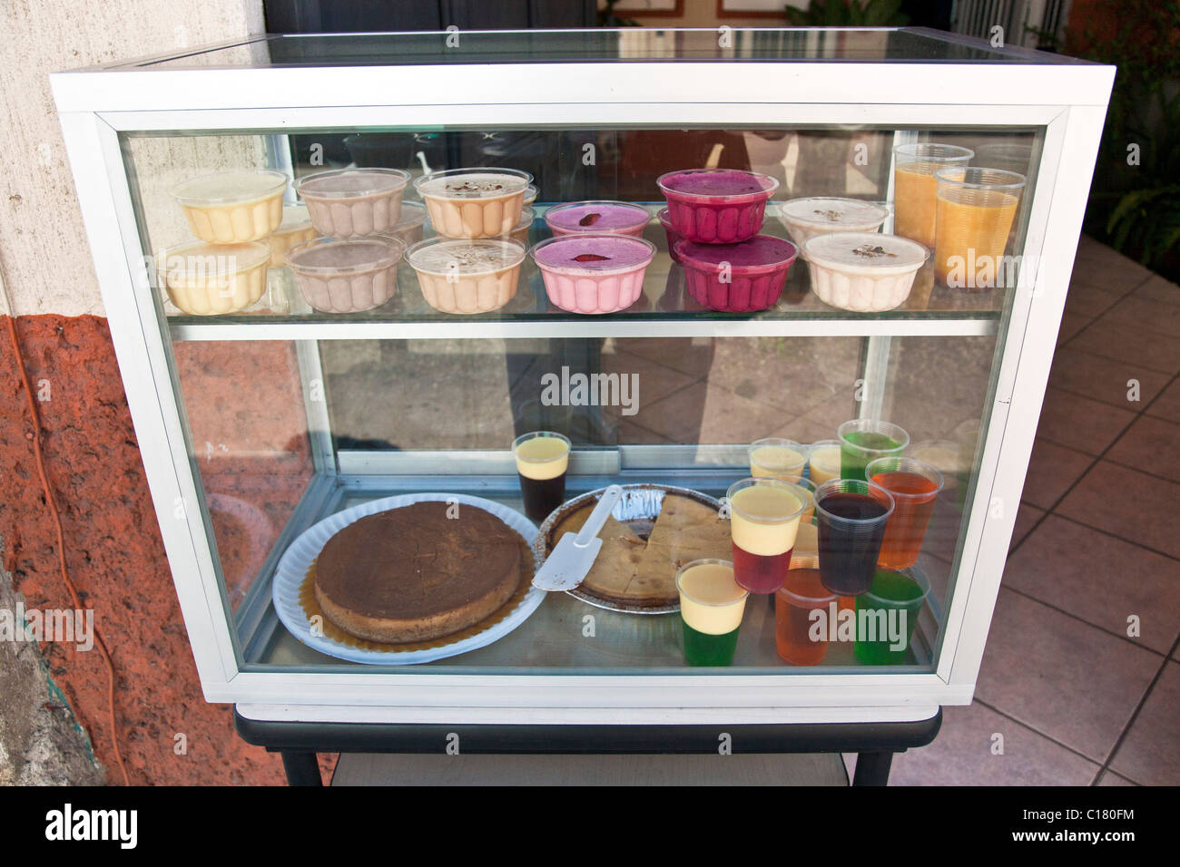 Array der köstlich zart farbigen Gelatine Desserts in Vitrine in offene Tür auf Straße Oaxaca Mexico Stockfoto