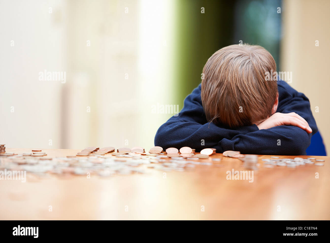 Kopf des jungen auf Armen umgeben von Münzen Stockfoto