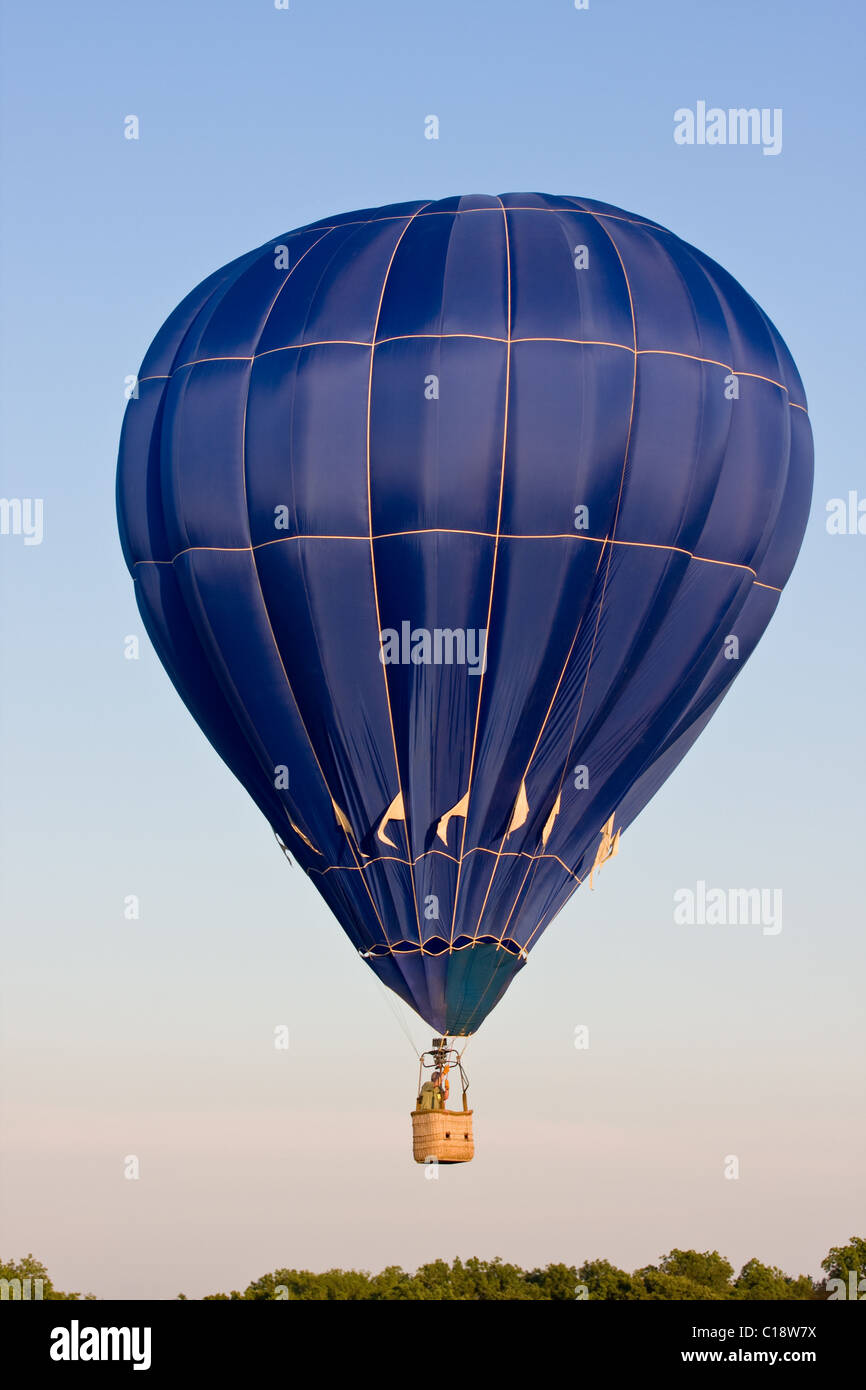 Ein bunte blaue Heißluftballon auf einem Festival schwebt in der Luft an einem klaren Tag. Stockfoto