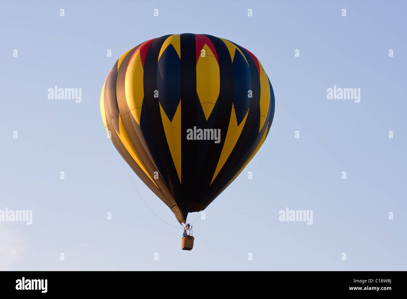 Ein bunter Heißluftballon auf einem Festival schwebt in der Luft an einem klaren Tag. Stockfoto
