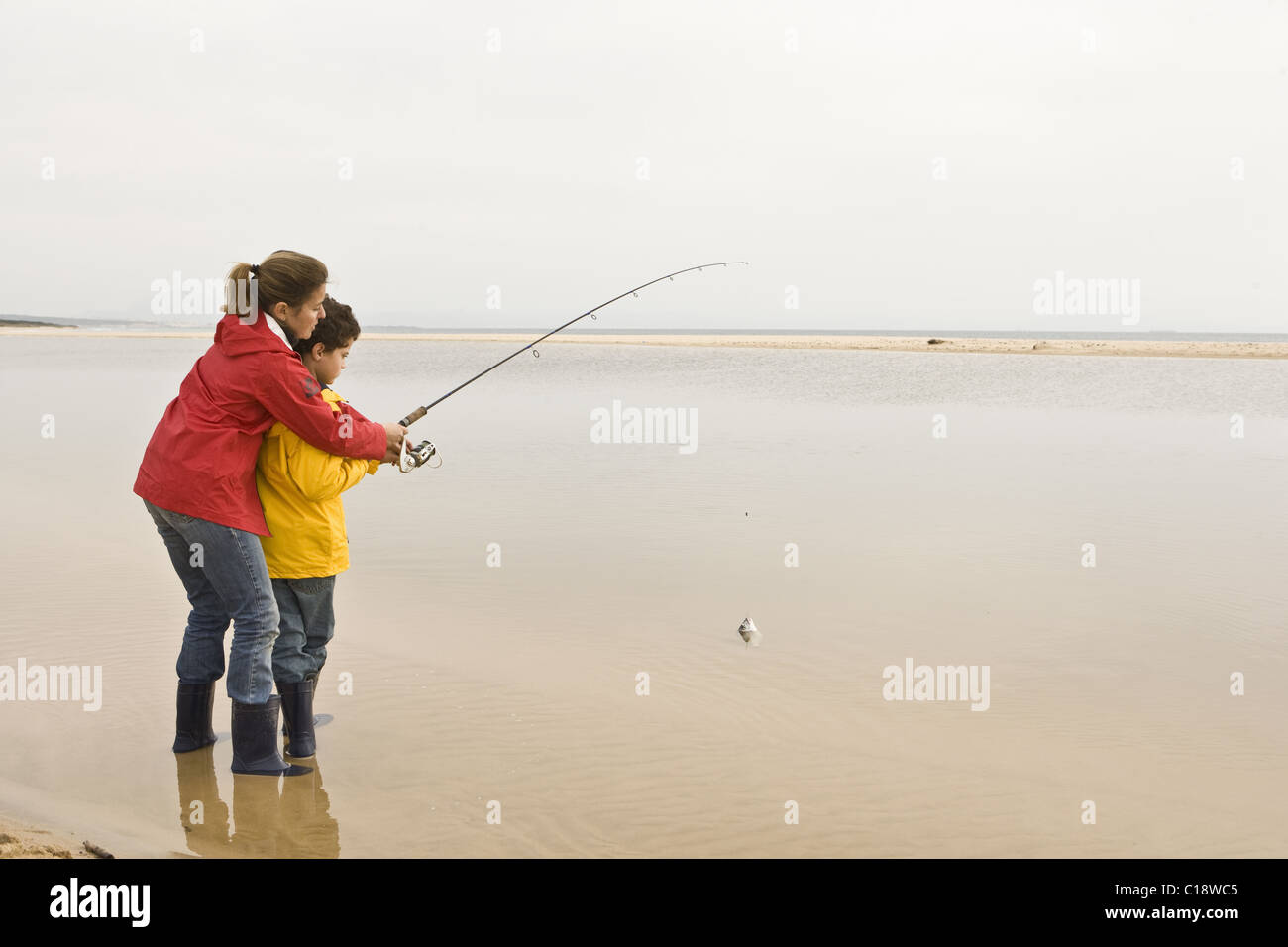 Sohn Mutter Unterricht am Strand Angeln Stockfoto