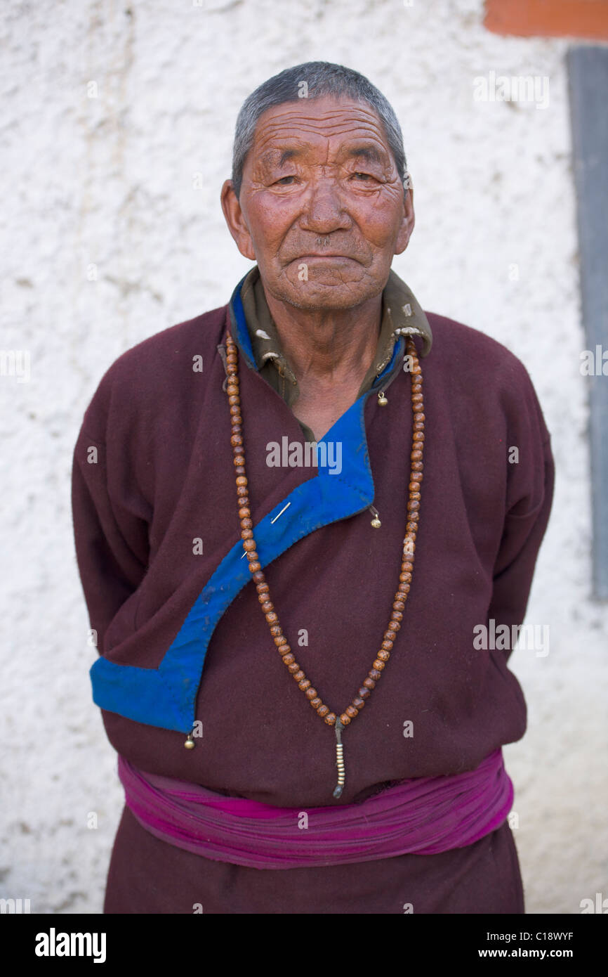 Ladakhi Greis in traditioneller Tracht mit Gebetskette im Gästehaus (Ladakh) Jammu & Kaschmir, Indien Stockfoto