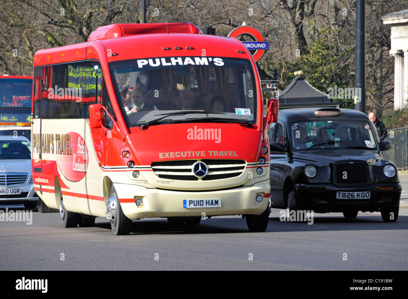 Pullmans executive Mercedes-Benz Minibus und Bus Reisen neben Schwarz London Taxi (Gesichter verdeckt) fahren im Hyde Park London England Großbritannien Stockfoto