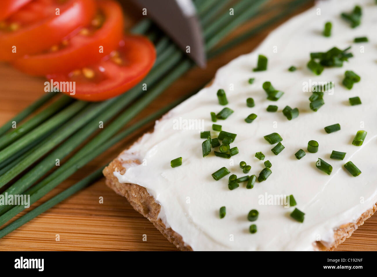 Knäckebrot, Frischkäse, Schnittlauch, Messer, Tomate, Holzbrett ... Knäckebrot, Frischkäse, Schnittlauch, Messer, Tomate, Holzbrett ...