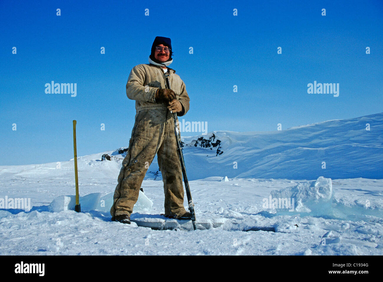 Inuit-Angeln in ein Eisloch im Fluss Colville, Nuiqsut, an der Küste des arktischen Ozeans im hohen Norden von Alaska Stockfoto