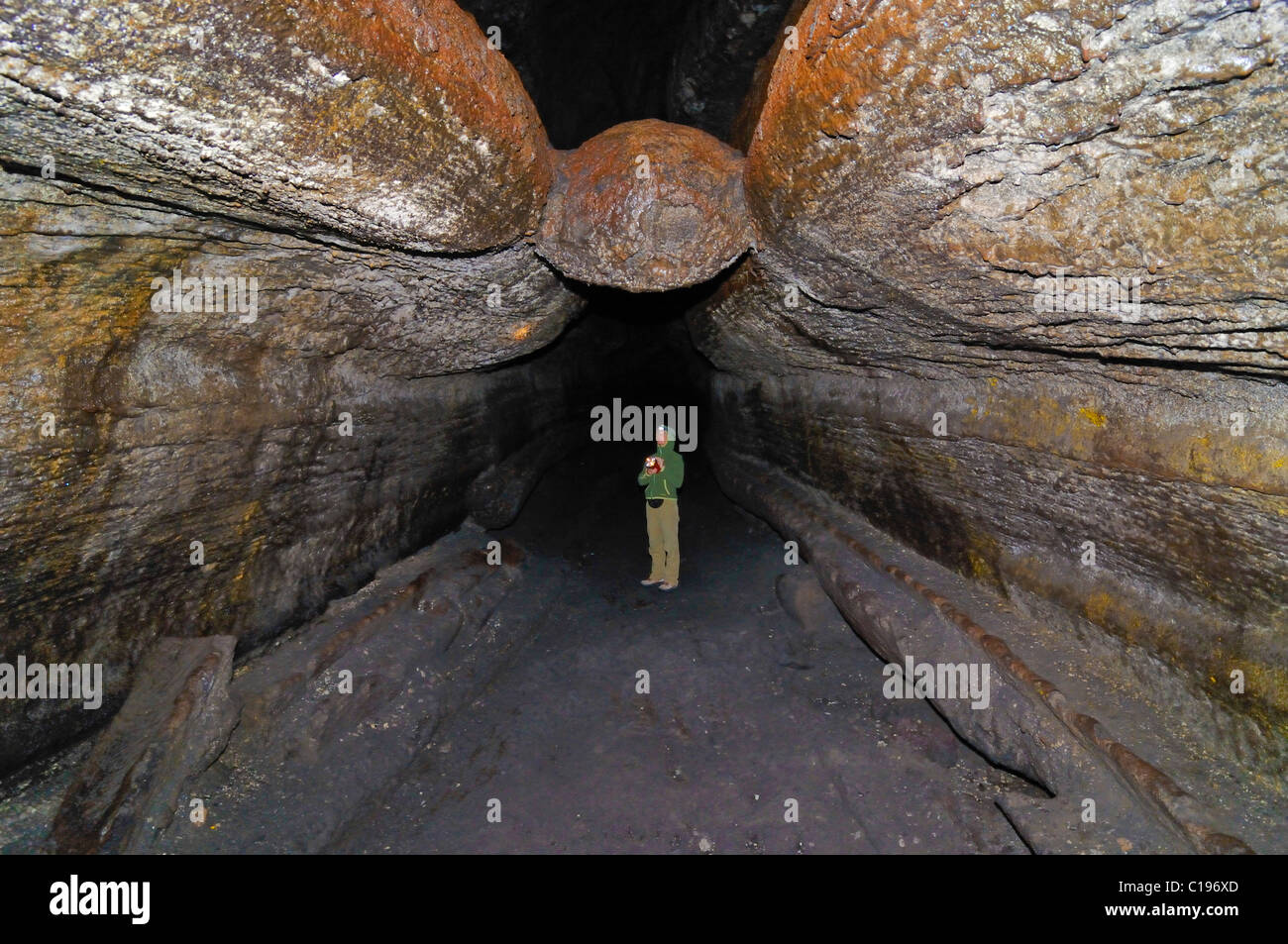 Lava-Fluss-Höhle, Höhlenforscher tragen eine Stirnlampe in einer vulkanische Lava Tube, Newberry National Volcanic Monument Stockfoto