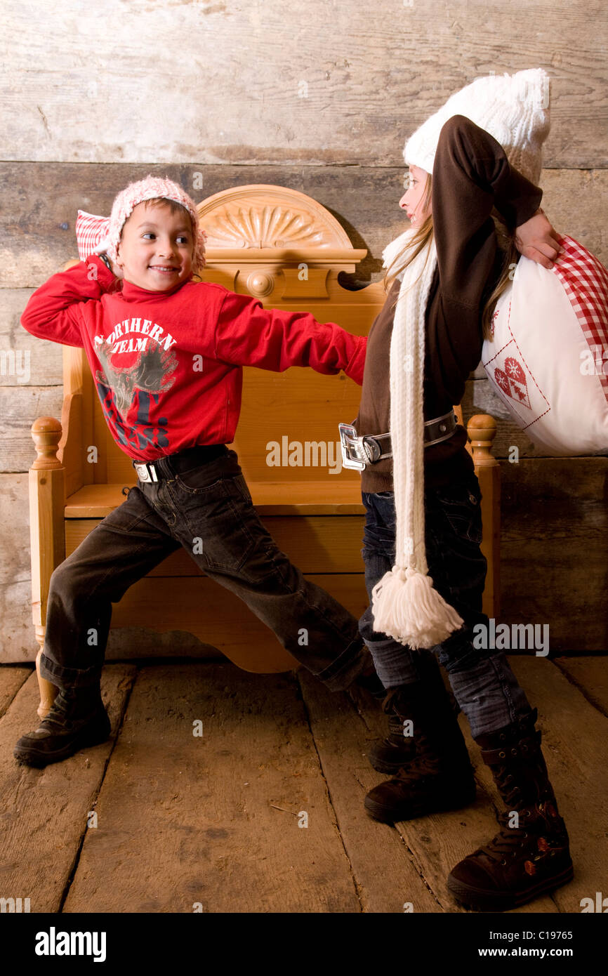 Zwei Geschwister mit einem Kissen zu kämpfen, in einer Hütte Stockfoto