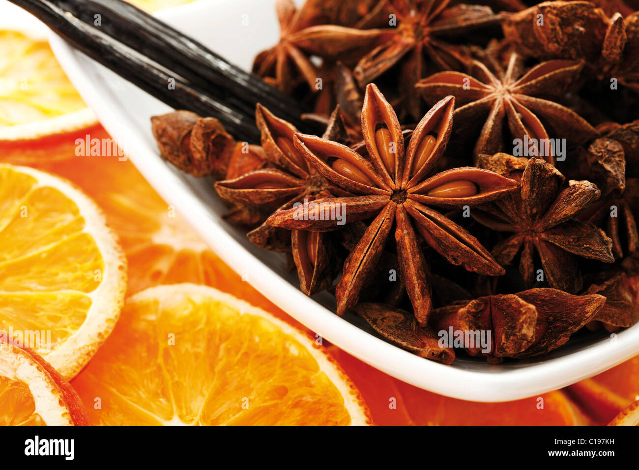 Getrocknete Orangenscheiben mit Vanille und Sternanis in Schüssel weiß Stockfoto