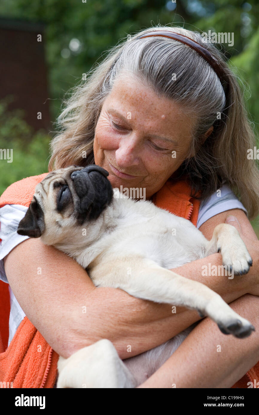 Porträt, weibliche Rentner, 60 +, sportlich, fürsorglich, Hund, Mops, Welpen Stockfoto