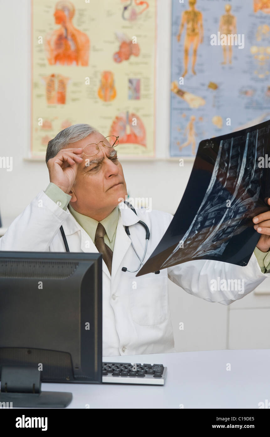 Arzt untersucht einen Röntgen-Bericht Stockfoto