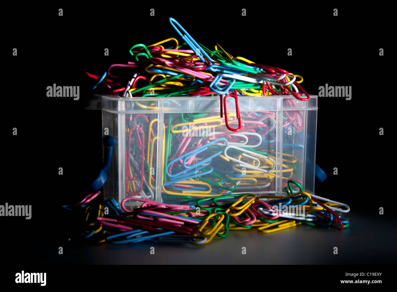 Farbige Büroklammern Herausfallen aus einer kleinen Kunststoff-box Stockfoto