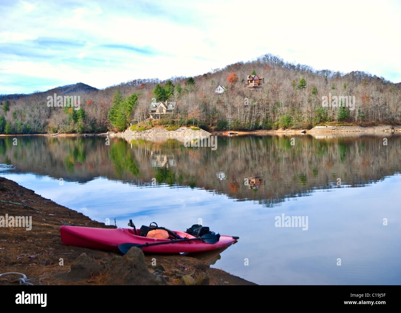 Eine rote Kajak hochgezogen am Ufer im Winter. Stockfoto
