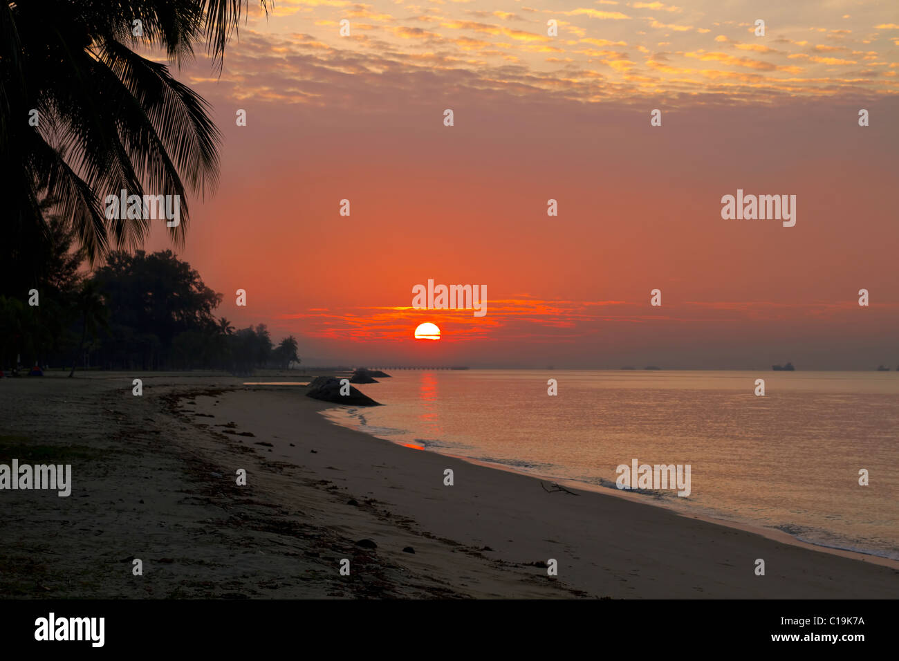 Sonnenaufgang über dem Horizont am East Coast Park Beach in Singapur Stockfoto