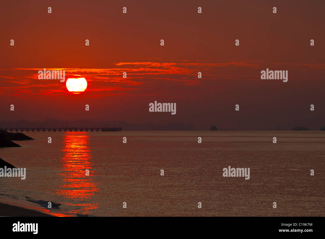 Sonnenaufgang über dem Steg am East Coast Park Beach in Singapur Stockfoto