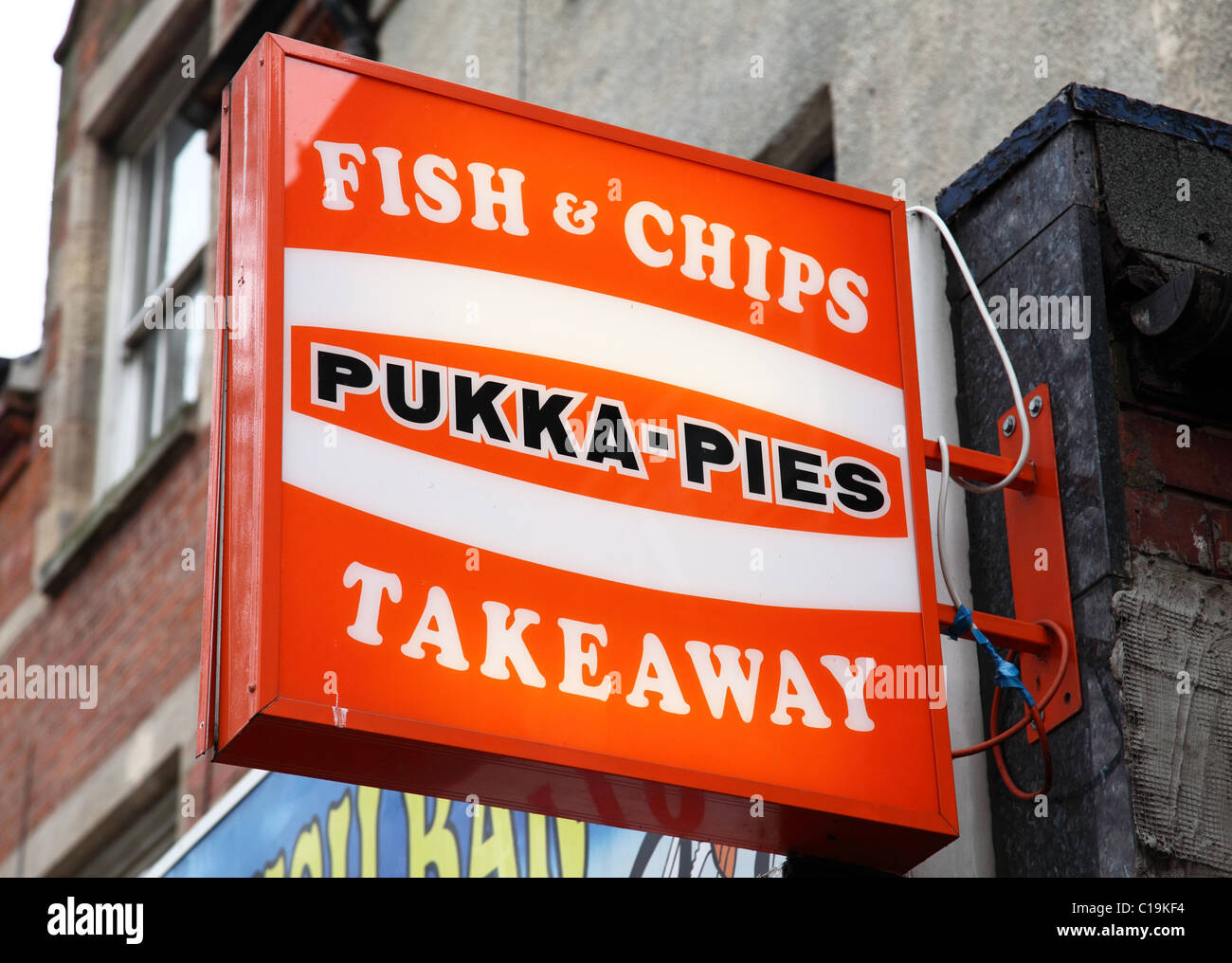 Pukka Pies Zeichen vor einem Fisch & Chip Shop in einer Stadt, U.K. Stockfoto