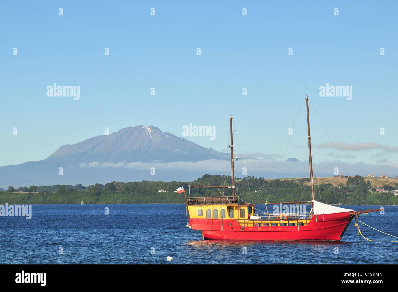 Blauer Himmelsblick auf roten Galeone erinnernden Vergnügungsdampfer vertäut am See Llanquihue, in Richtung Volcan Calbuco aus Puerto Varas, Chile Stockfoto