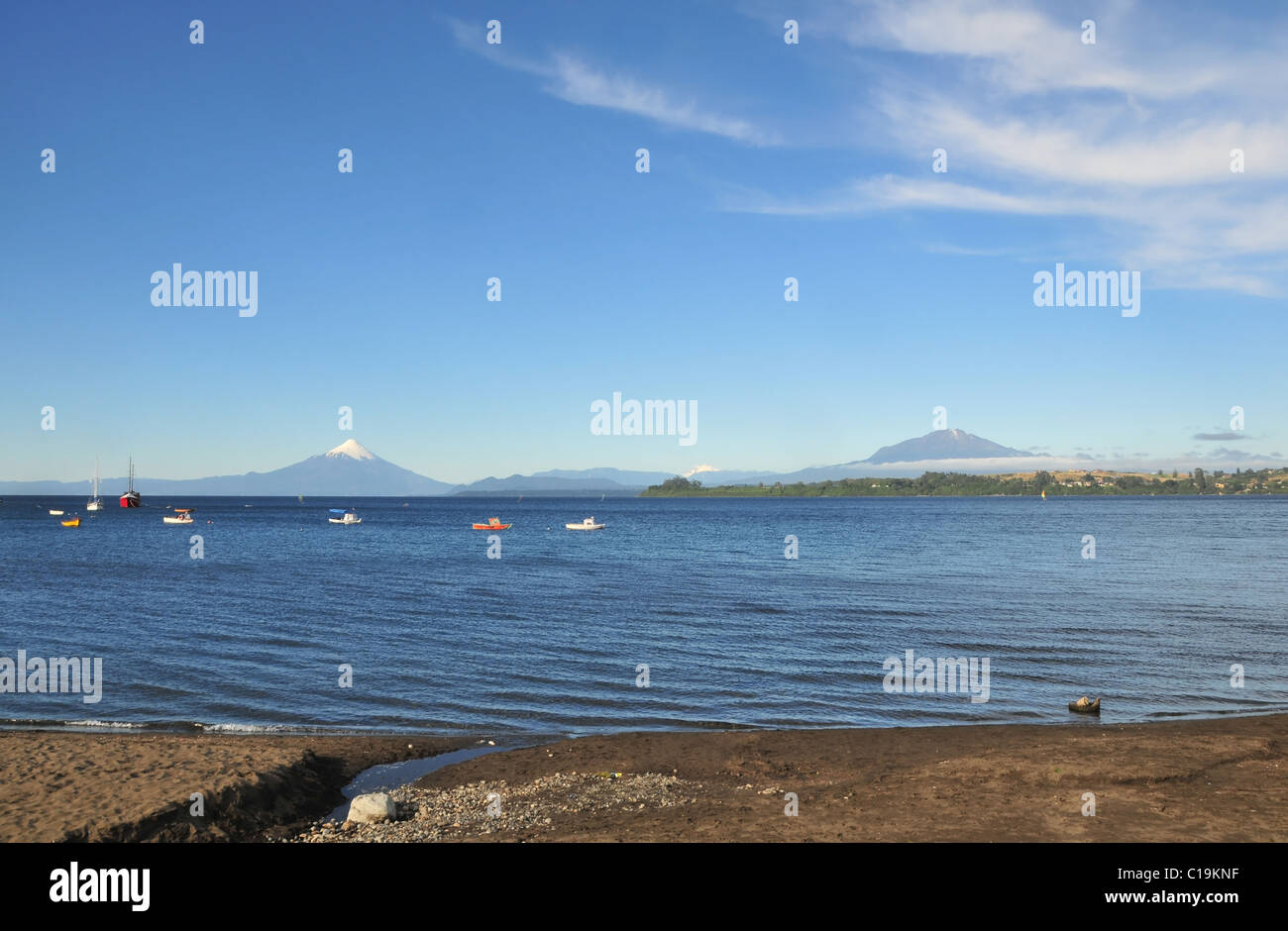 Blauer Himmel Strandblick, Osorno und Calbuco Vulkane, von kleinen Booten auf See Llanquihue, Puerto Varas, Chile Stockfoto