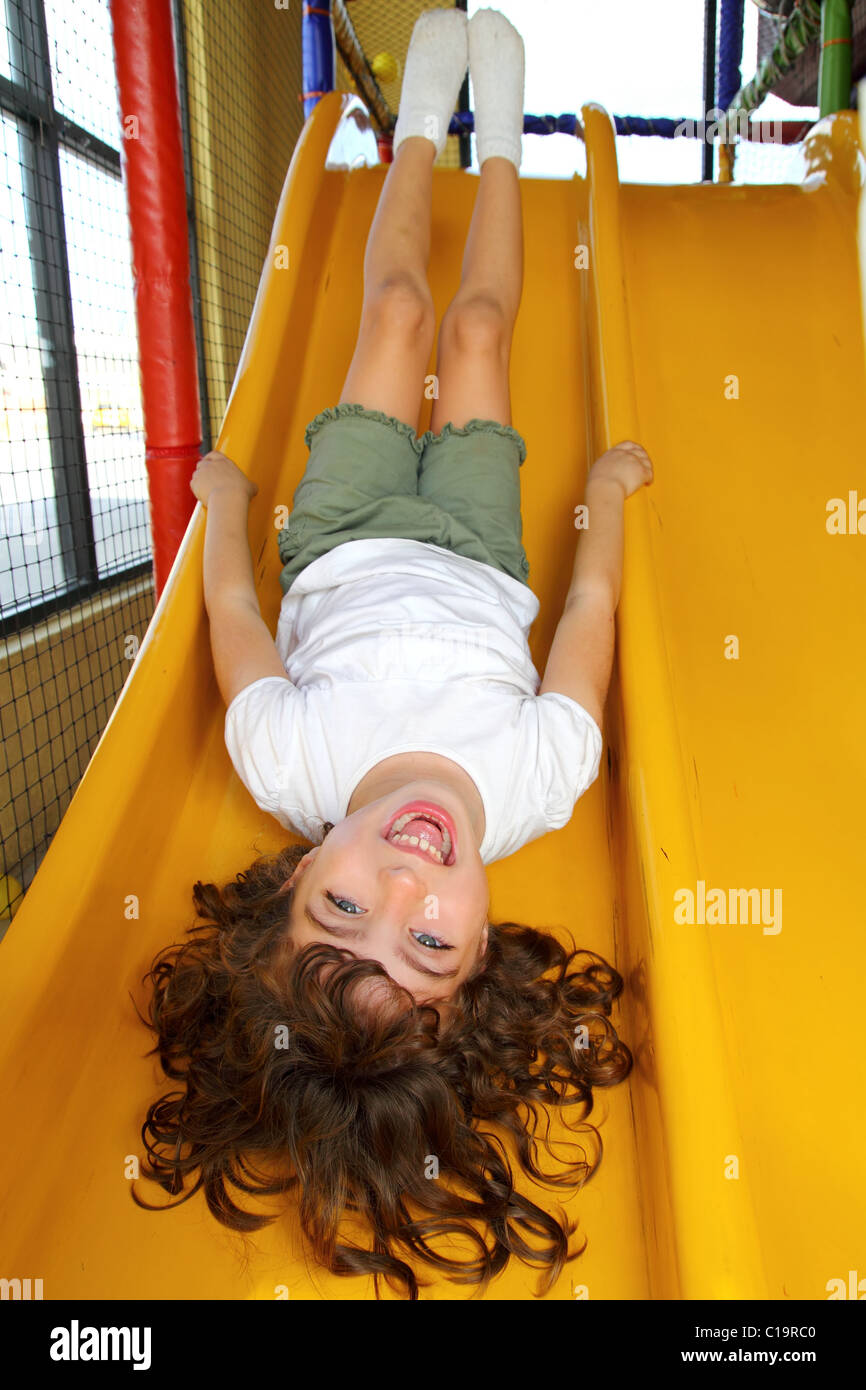 kleines Mädchen auf Spielplatz Folie lacht glücklich auf den Kopf verharmlosen Stockfoto