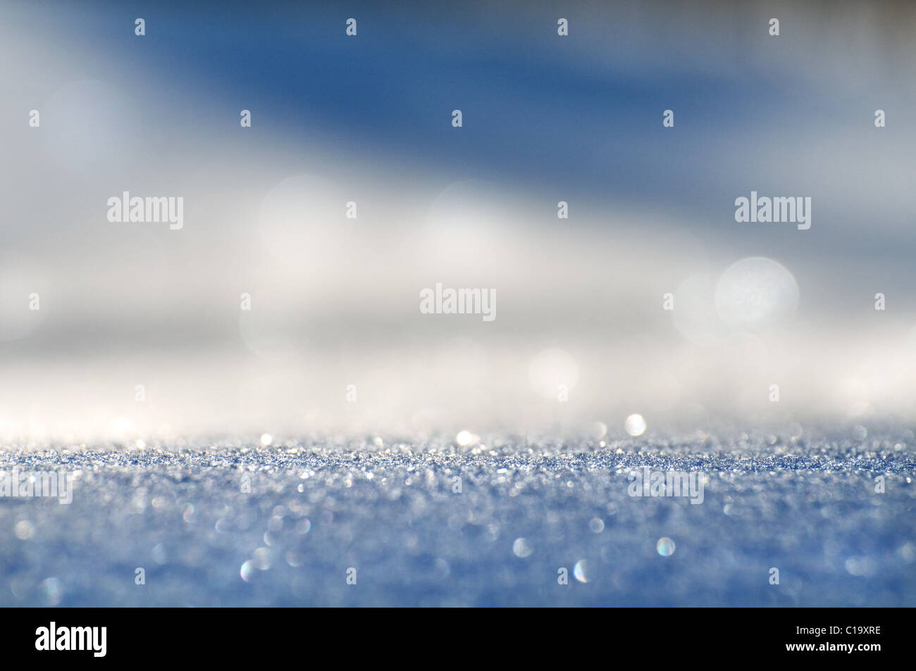 Funkelnden Schnee weiß-blauen Hintergrund mit helle Lichtflecken. Es wird auf soft-Fokus entfernt. Stockfoto