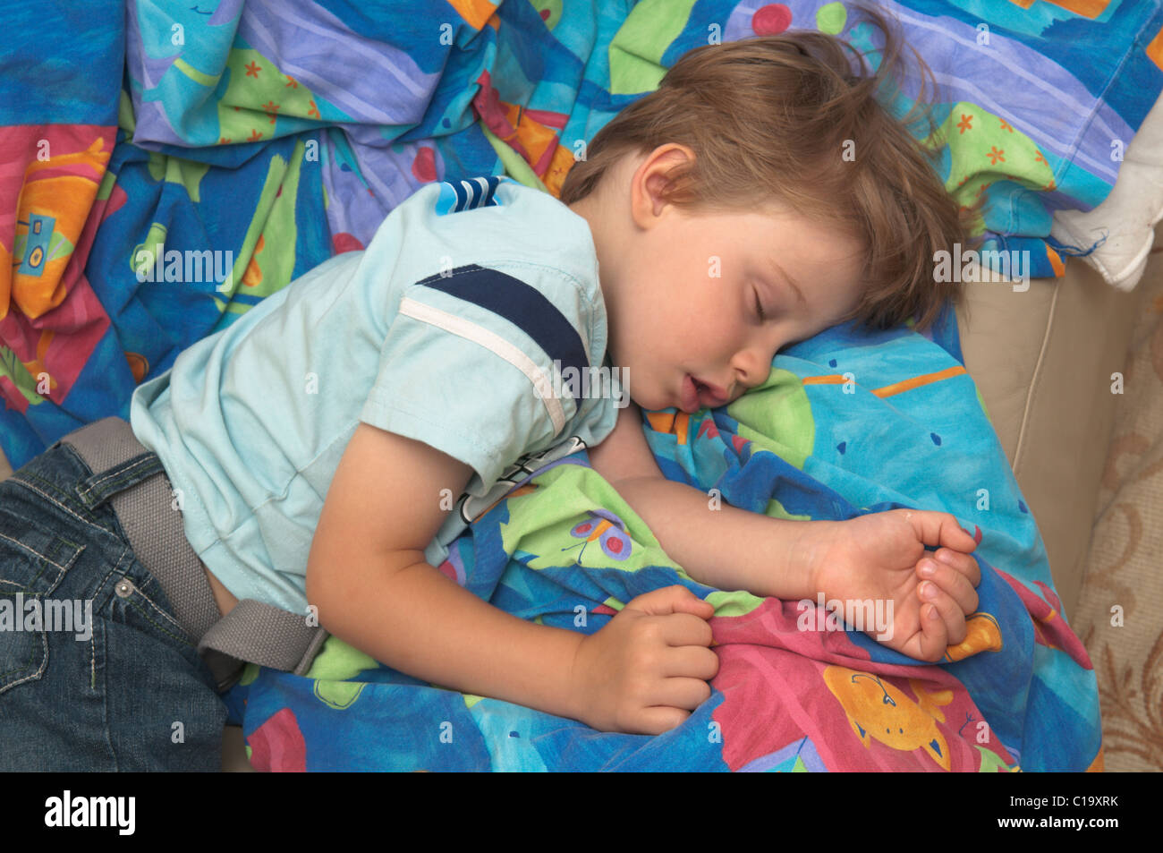 vier Jahre alter Junge auf Sofa eingeschlafen Stockfoto