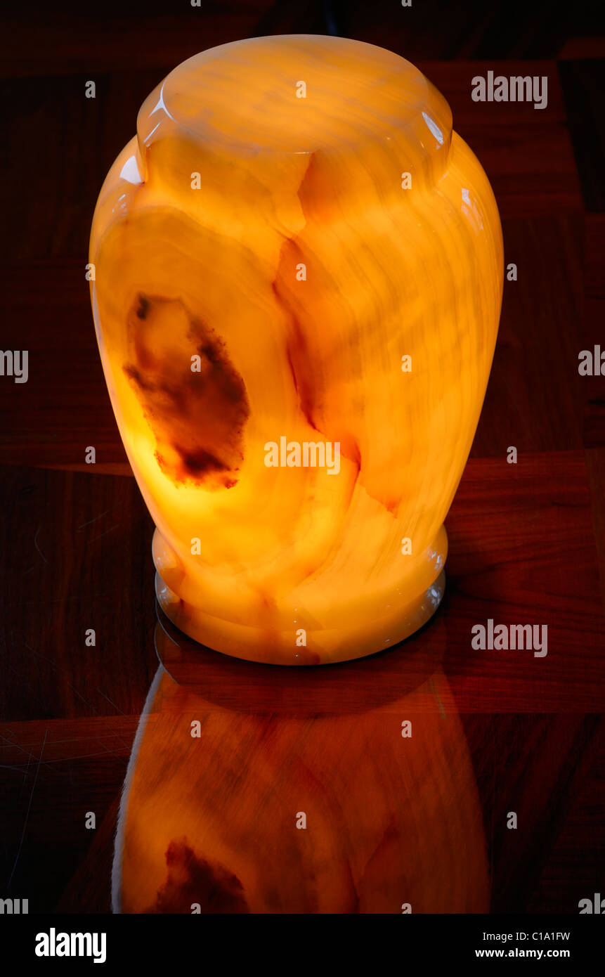 Onyx Stein Einäscherung urn glühende mit einer inneren Licht auf einen hölzernen Tisch Stockfoto
