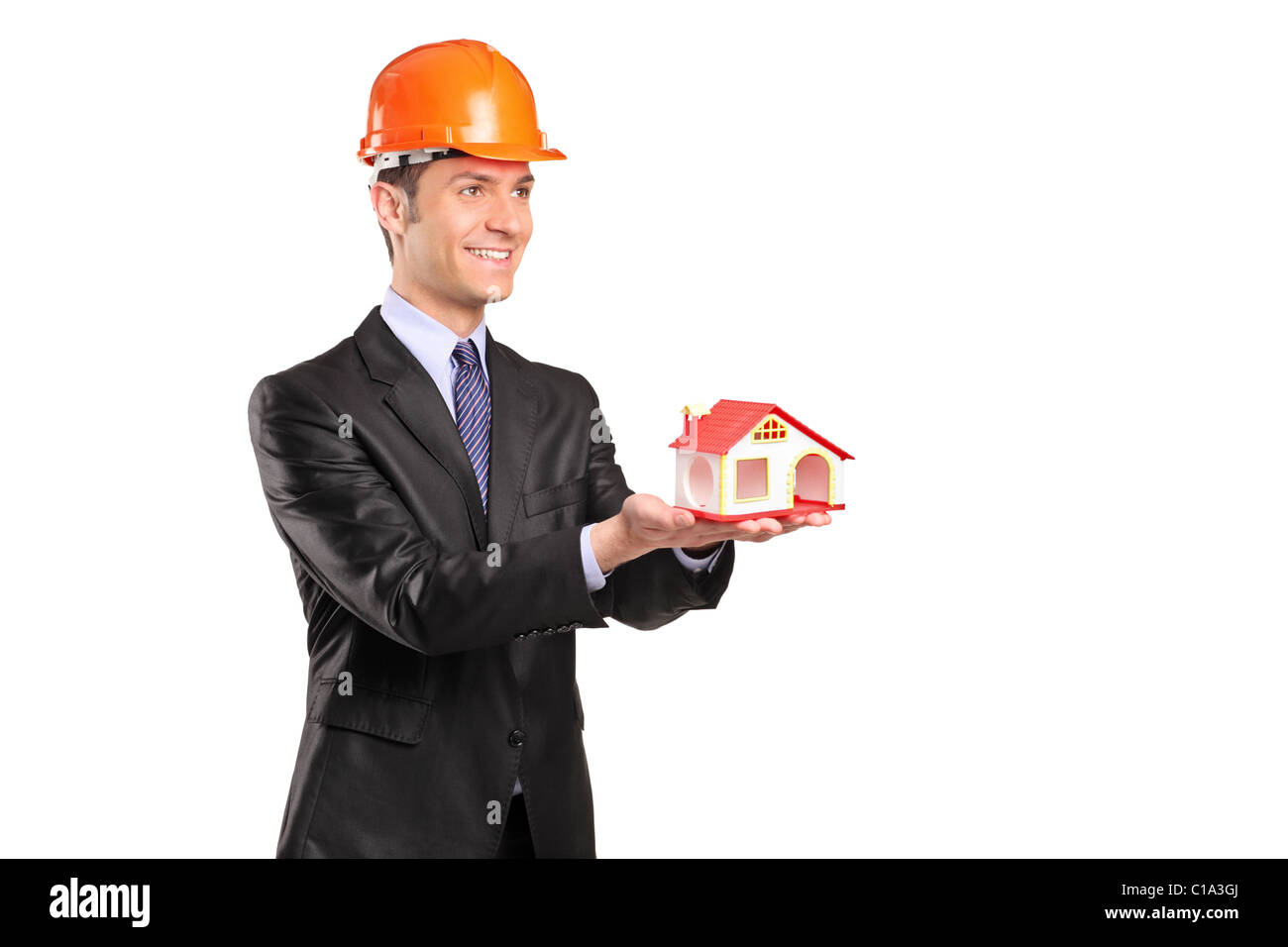 Vorarbeiter trägt Helm und hält ein Modell des Hauses Stockfoto