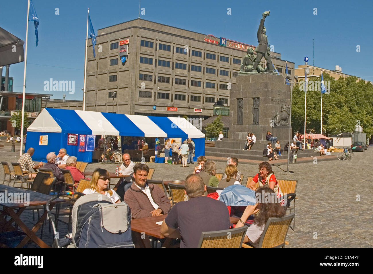 Europa, Finnland, Vaasa (Vasa), Marktplatz mit Menschen im Café und Denkmal am Heck Stockfoto