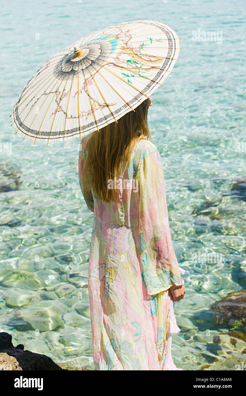 Junge Frau im Urlaub mit Sonnenschirm Stockfoto