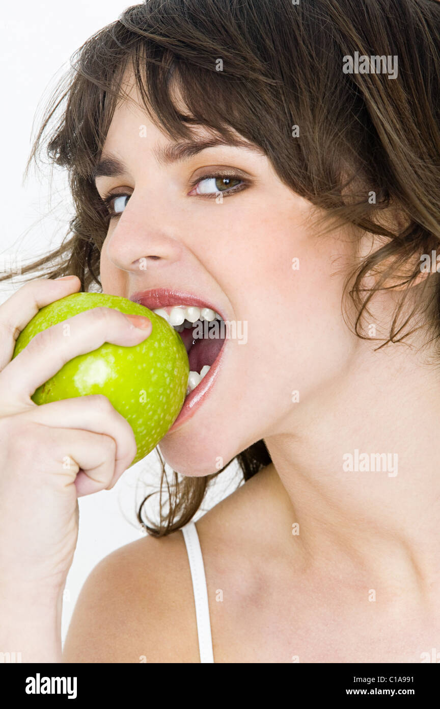 Portrait von junge Brünette Frau Essen Apfel Stockfoto