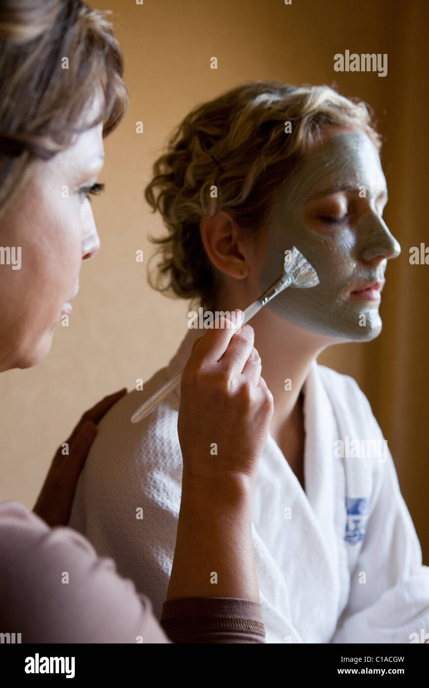 Junge Frau, die Schlamm-Maske auf dem Gesicht aufgetragen Stockfoto