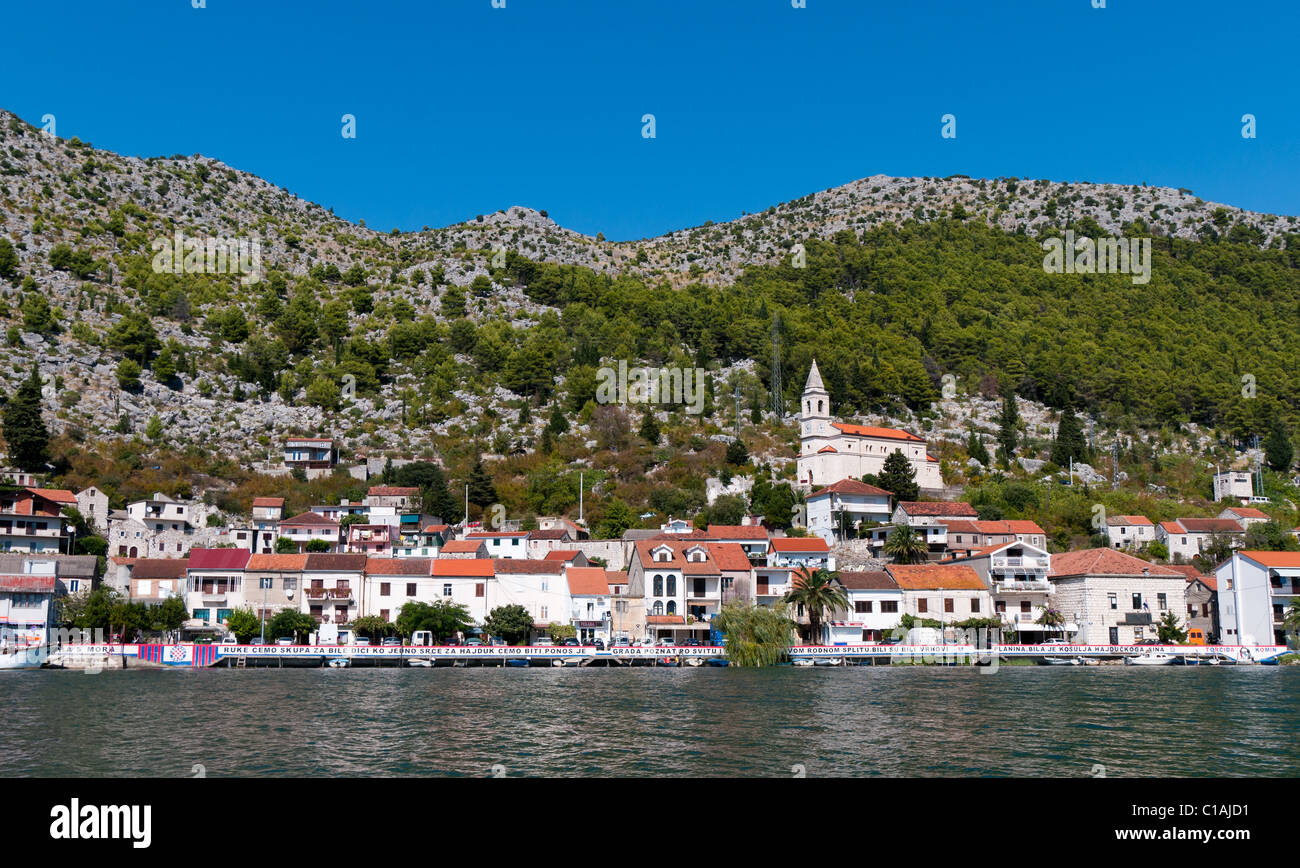 Traditionelle Stadt an der Adria. Häuser in der Nähe von das Meer und die katholische Kirche den Berg hinauf. Stockfoto