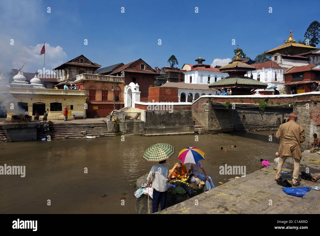 Hindu Preist Durchführung zeremonielle Riten für den verstorbenen am Pashupatinath Feuerbestattung Standort am Fluss Bagmati Kathmandu-Nepal Stockfoto