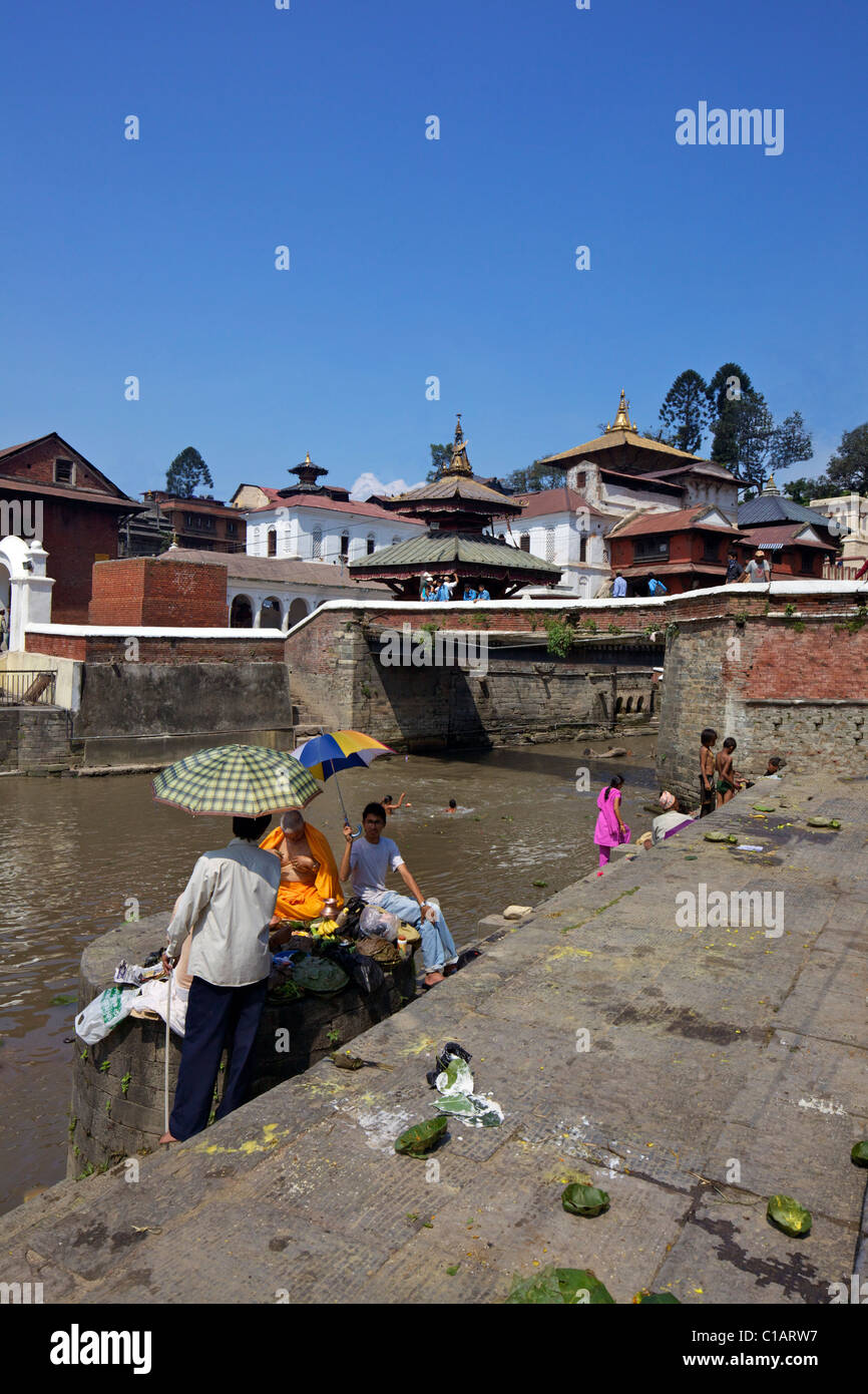 Hindu Preist Durchführung zeremonielle Riten für den verstorbenen am Pashupatinath Feuerbestattung Standort am Fluss Bagmati Kathmandu-Nepal Stockfoto