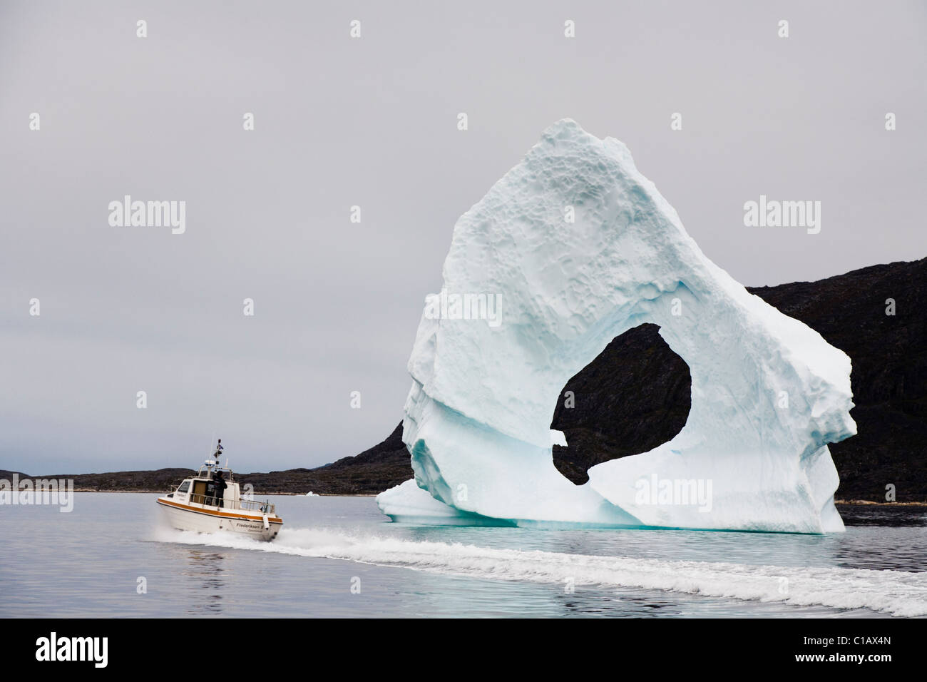 Gewölbte Eisberg, Boot segeln vorbei, Süd-Grönland. Stockfoto