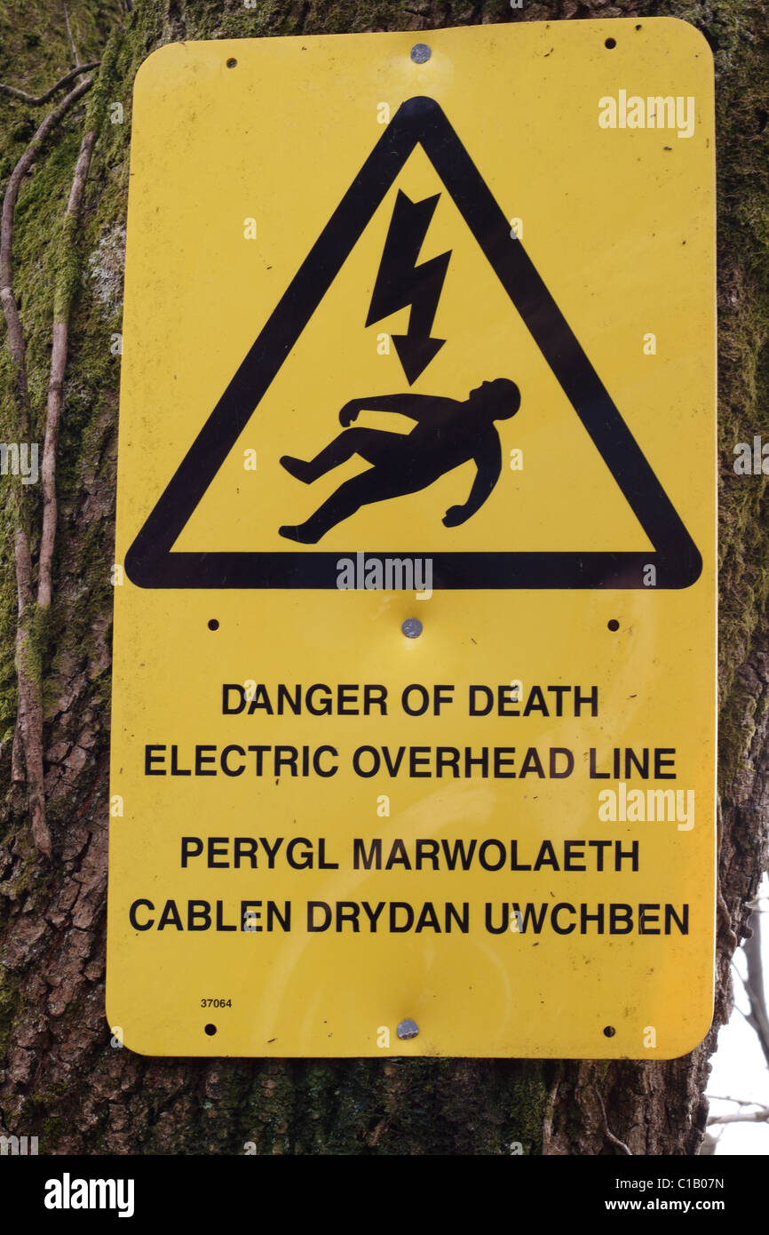Gelbe Strom overhead line warnen zweisprachige Welsh/Englisch Hinweis, befindet sich am Ufer des Kanals um Fischer zu warnen. Stockfoto