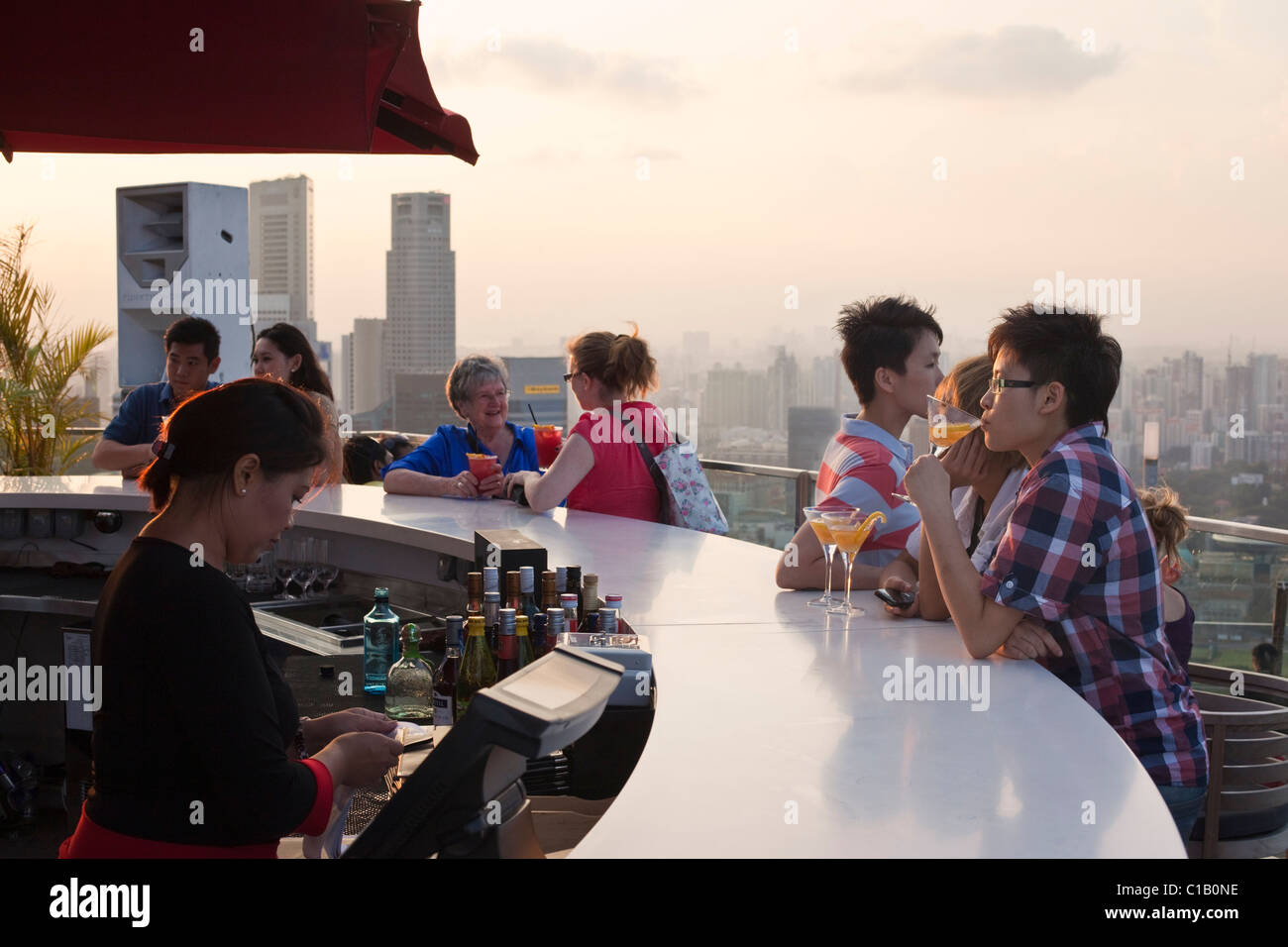 Sunset drinks an der Bar auf dem Dach des Marina Bay Sands SkyPark - 200 m über der Stadt.  Marina Bay, Singapur Stockfoto