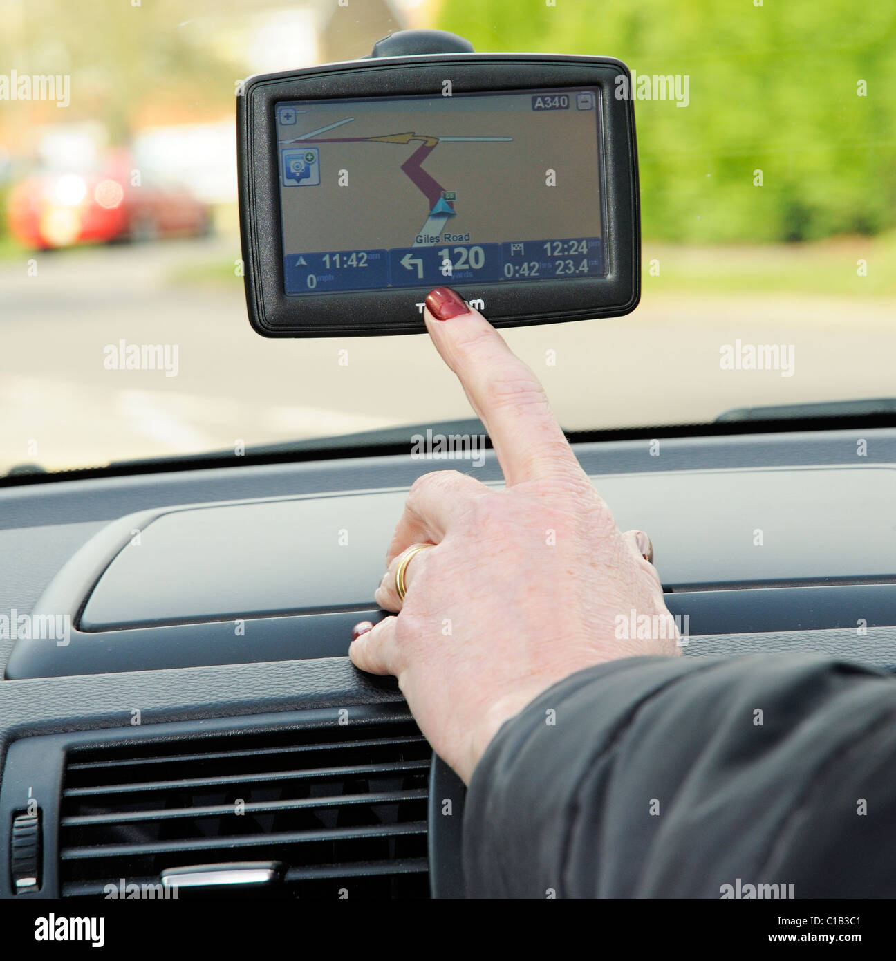 Frau Treiber mit einem TomTom Sat Nav-Gerät Stockfoto