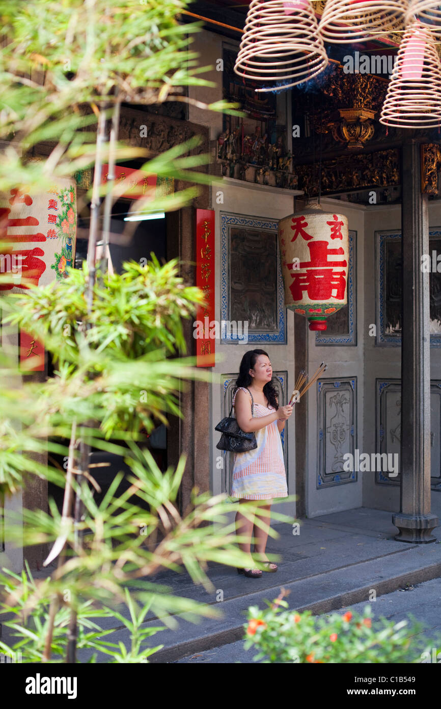 Frau mit Weihrauch an der Wak Hai Cheng Bio Tempel. Raffles Place, Singapur Stockfoto