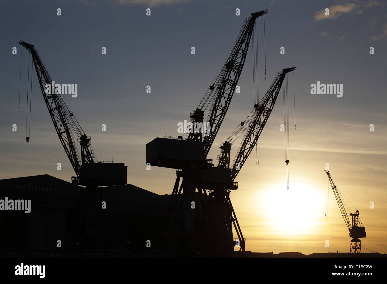 Sonnenuntergang über die Krane bei BAE Systems-Werft in Govan, Glasgow, Schottland, UK Stockfoto