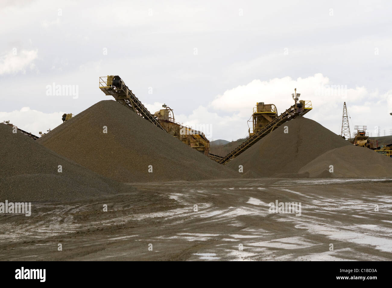 Haufenweise Sand sammeln sich in einer Kies-Bergbau-Fabrik. Stockfoto