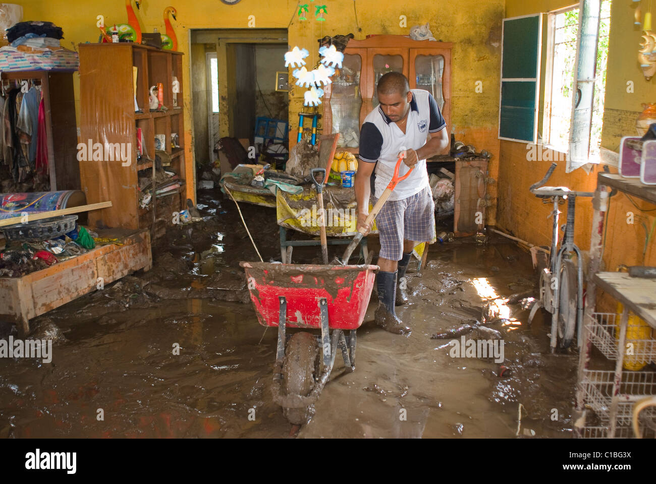 Irving Garcia, 24, Schaufeln Schlamm und Geröll, dass Hurrikan Karl bei seiner Familie zu Hause in La Posta, Veracruz hinterlegt. Stockfoto