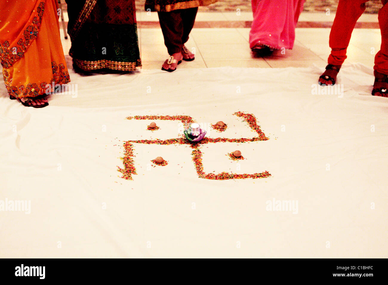 HAKENKREUZ-PEACE-Zeichen Hinduismus Jainismus Buddhismus Zeremonie zeremonielle Reis MADE Boden bunte indische Hochzeit rot hinduistischen Indien BUDDHI Stockfoto